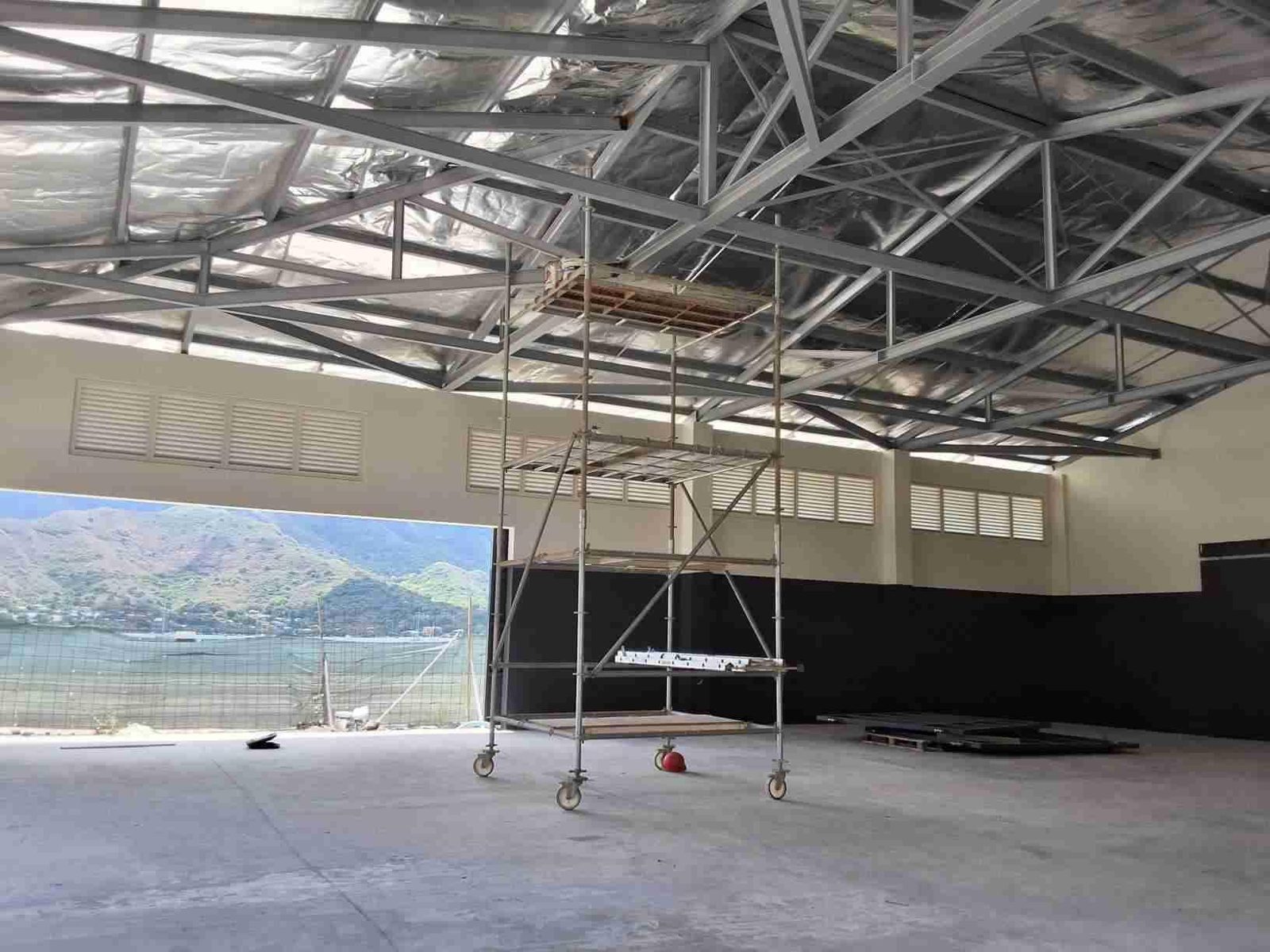 L’intérieur du hangar : charpente métallique et ouverture sur la baie