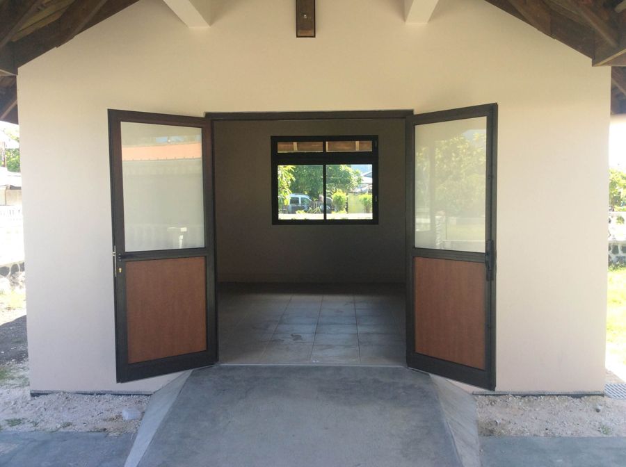L’entrée, portes ouvertes sur la salle carrelée